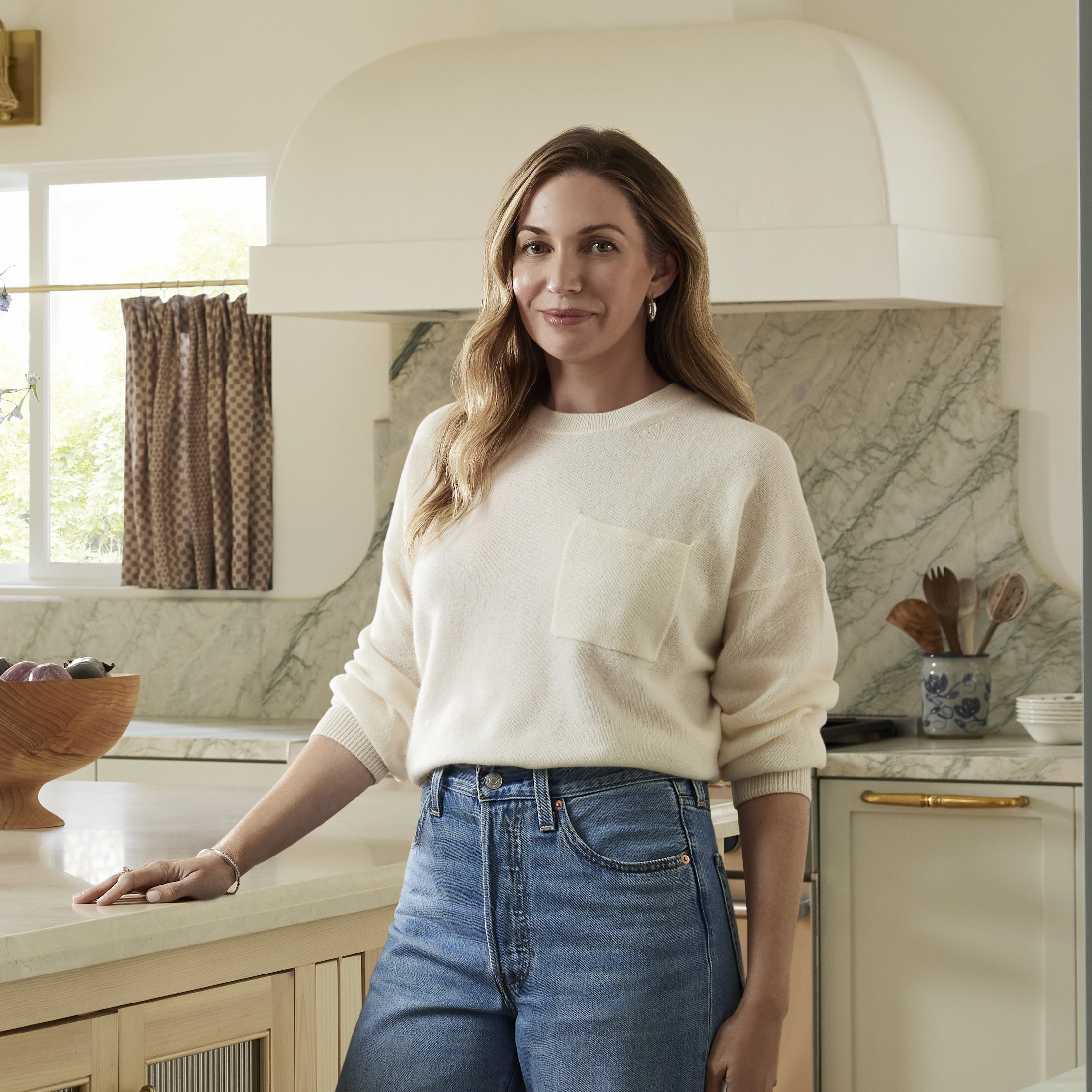 a woman standing in a kitchen next to a table