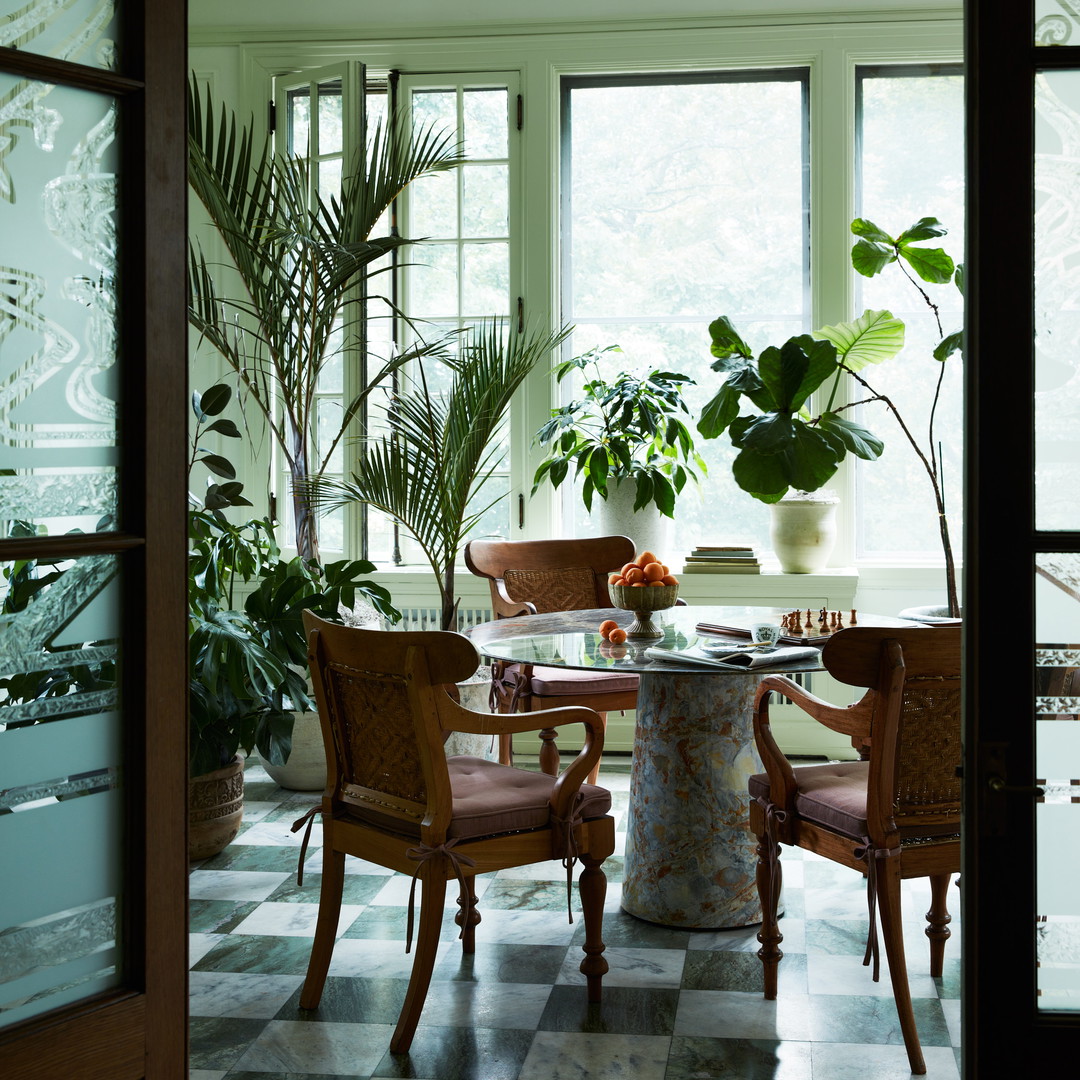 a dining room with a checkered floor and a potted plant