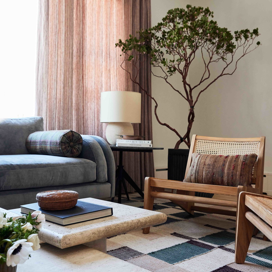 a living room filled with furniture and a tree