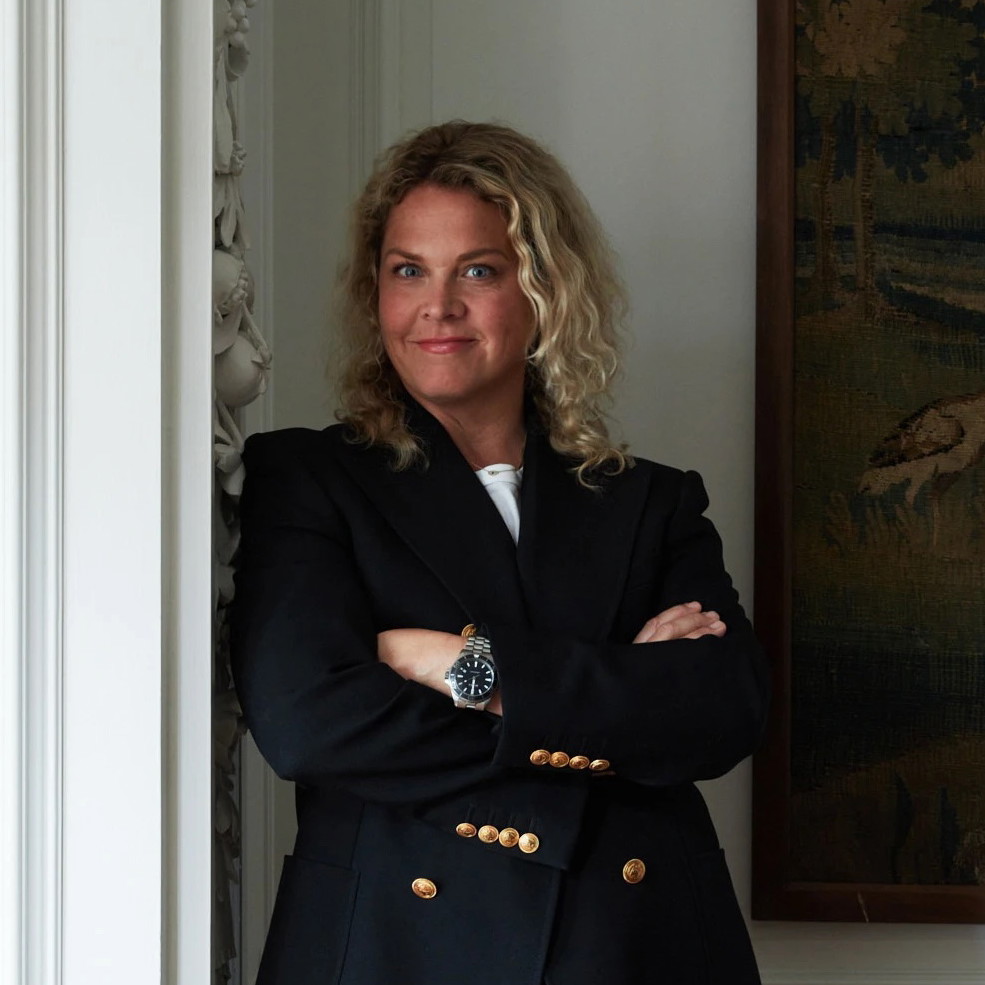 a woman with her arms crossed standing in front of a painting