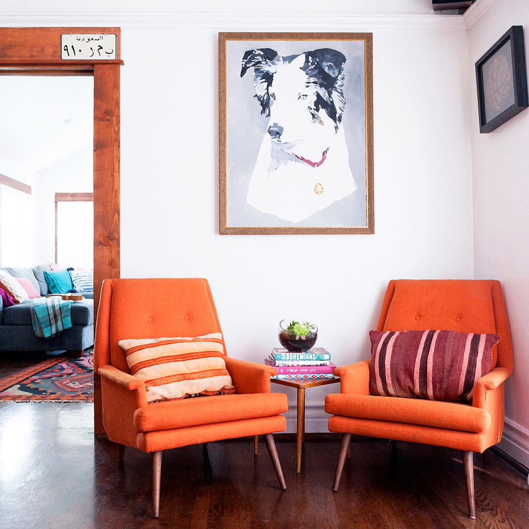 a living room with two orange chairs and a coffee table