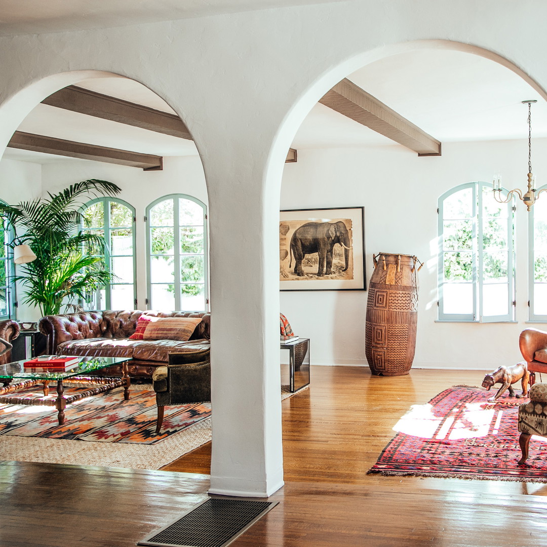 a living room filled with lots of furniture and windows