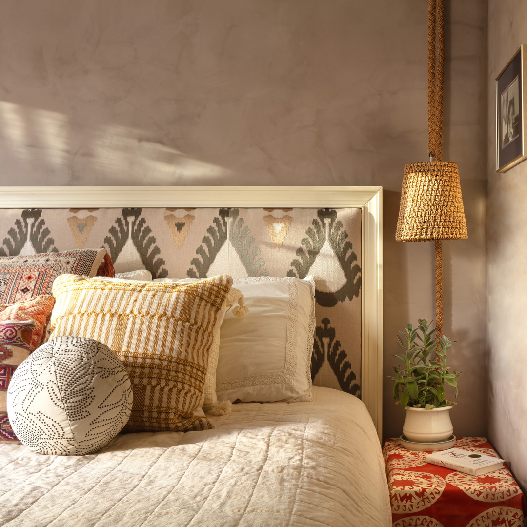 a bed with a white headboard and pillows on top of it