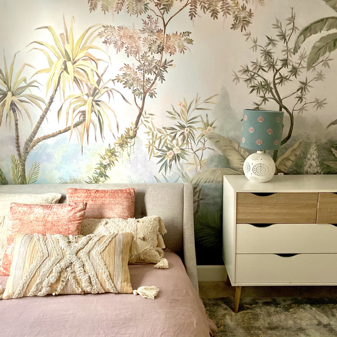 a bedroom with a bed, dresser and wall mural