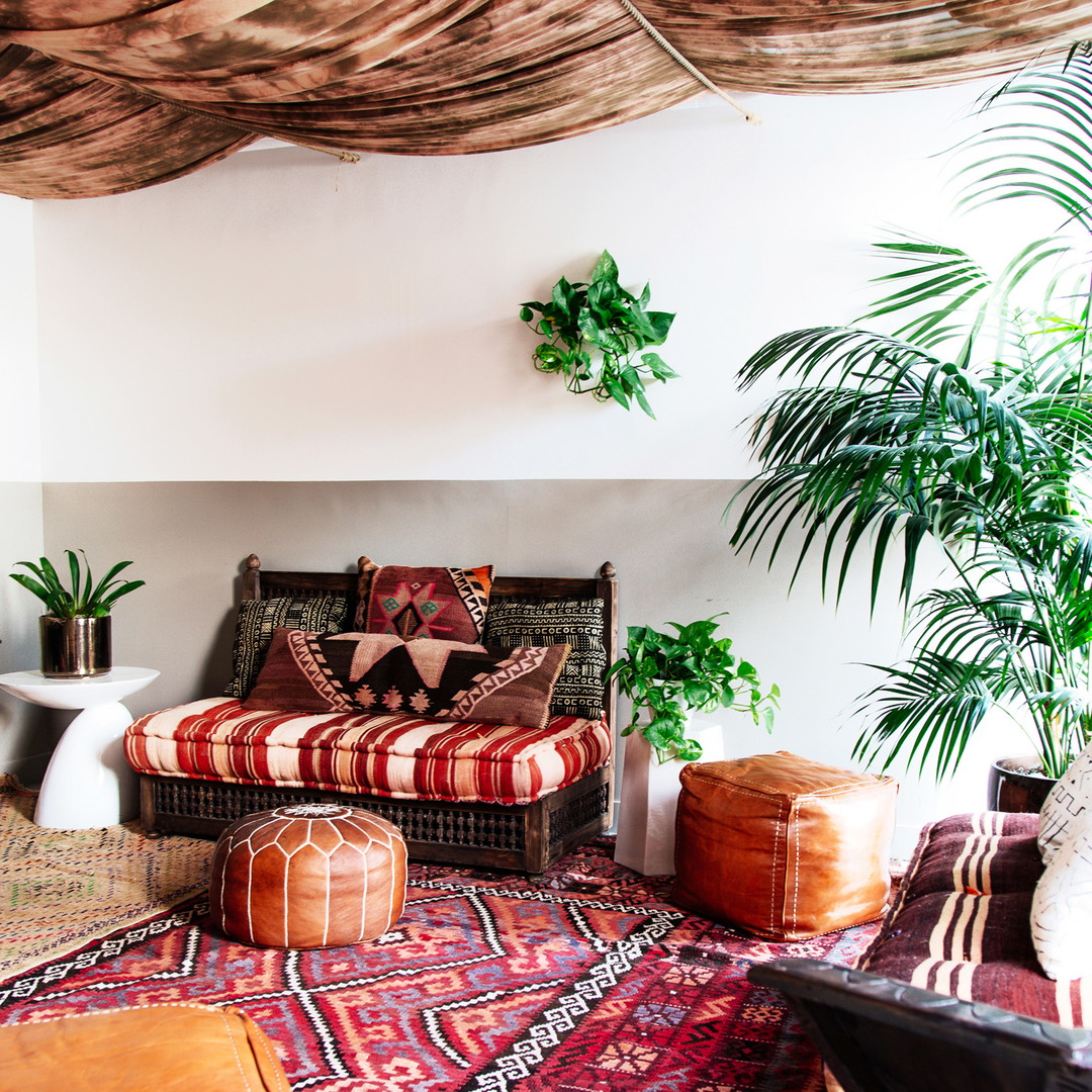 a living room filled with lots of furniture and plants