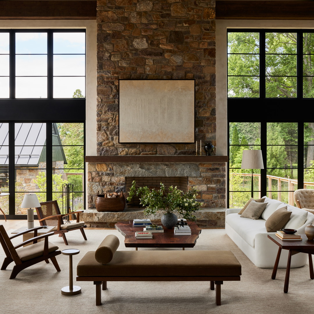 a living room filled with furniture and a stone fireplace