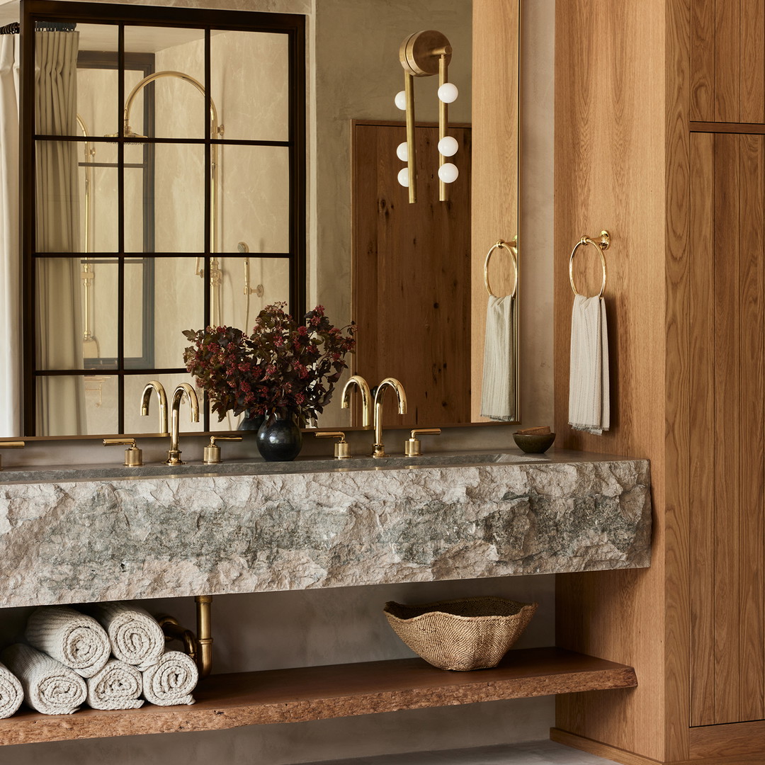 a bathroom with a marble counter top and wooden cabinets