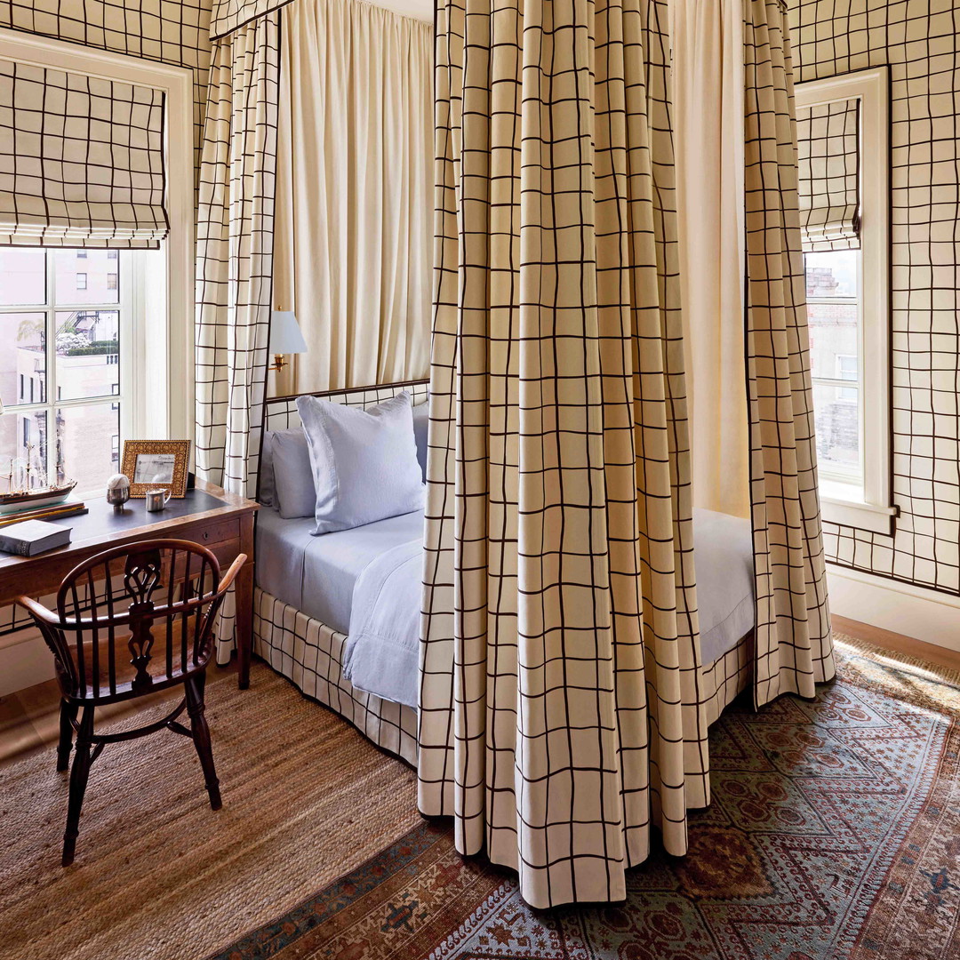 a four poster bed in a bedroom with a table and chairs