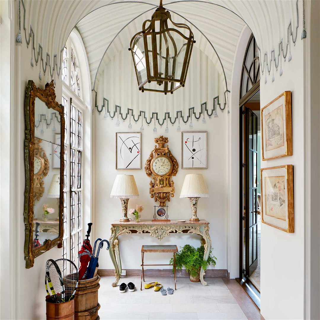 a hallway with a chandelier and a clock on the wall