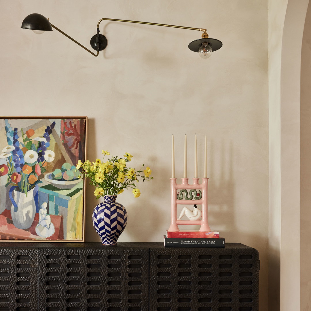 a vase of flowers sitting on top of a black cabinet