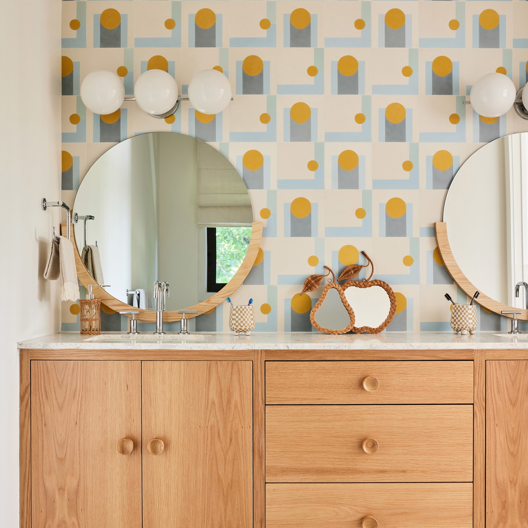 a bathroom with two mirrors and a wooden cabinet