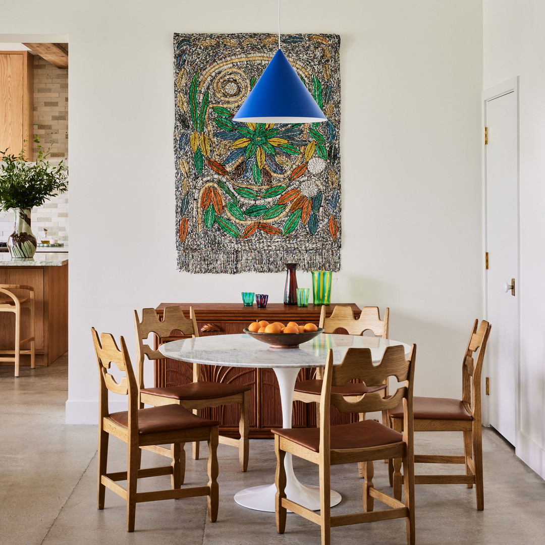 a dining room with a painting hanging on the wall