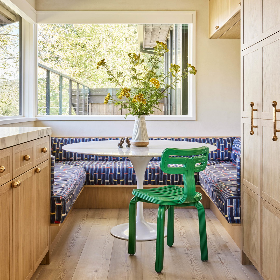 a green chair sitting in a kitchen next to a window