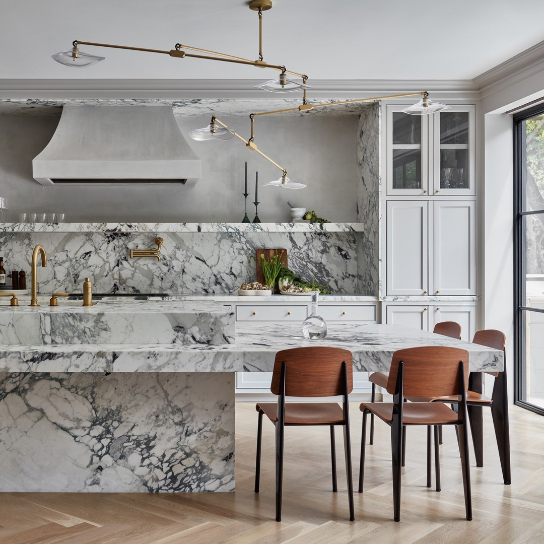 a kitchen with marble counter tops and chairs