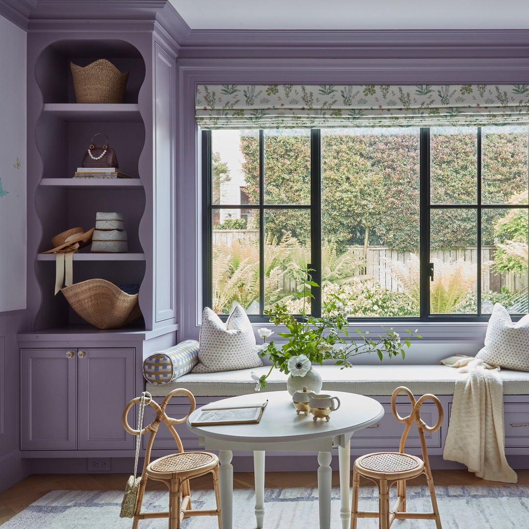 a room with purple walls and a white table and chairs