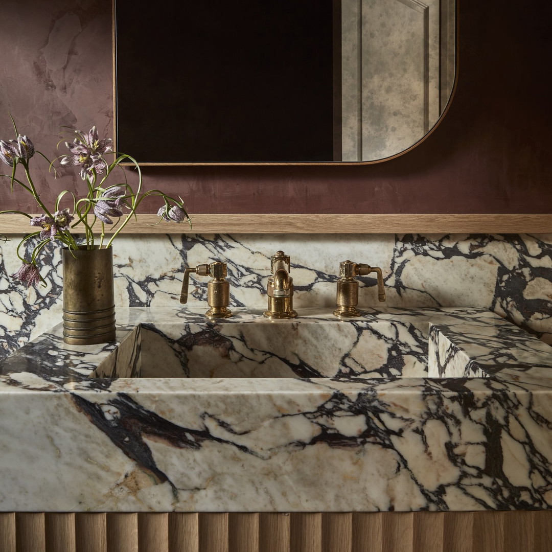 a bathroom sink with a vase of flowers on it