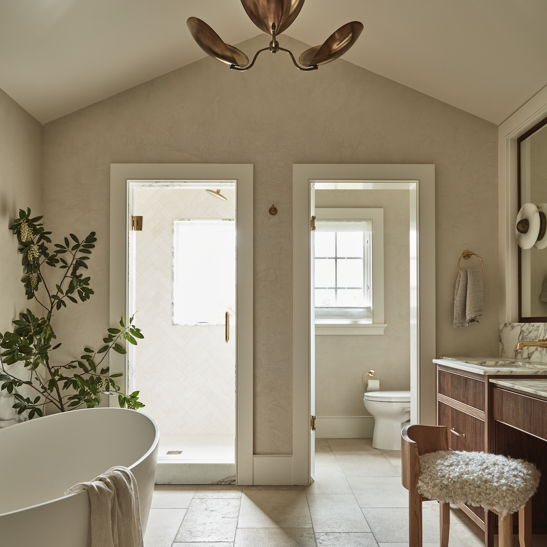 a bathroom with a tub, sink, mirror and a toilet