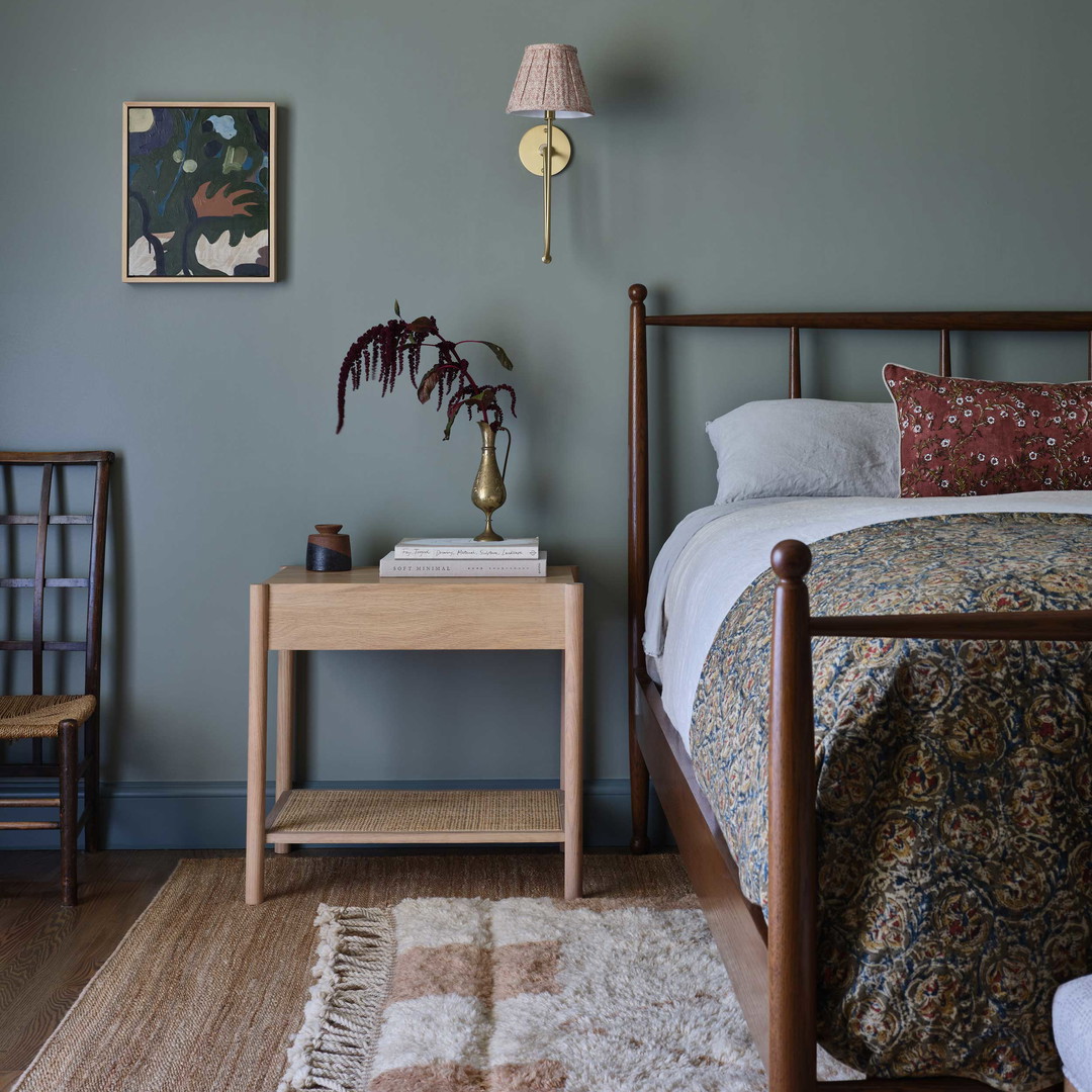 a bed room with a neatly made bed and a night stand