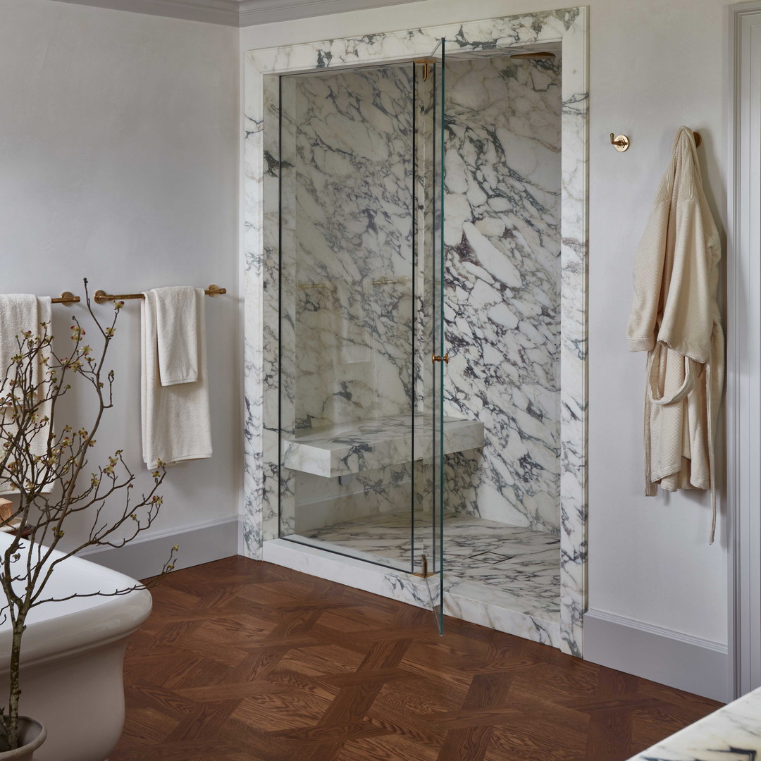 a bathroom with a glass shower door next to a toilet