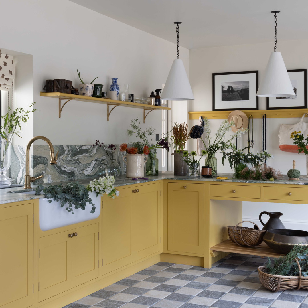 a kitchen with yellow cabinets and a checkered floor