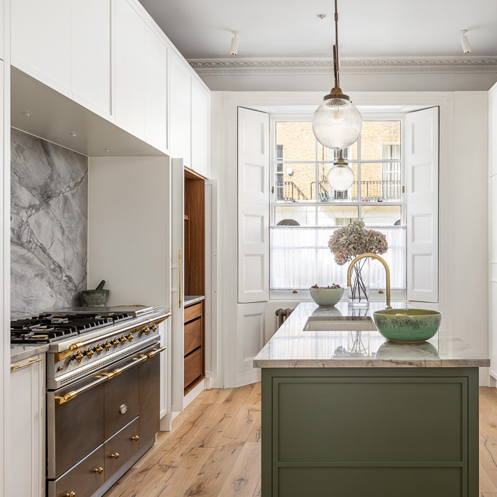 a kitchen with white cabinets and a green island