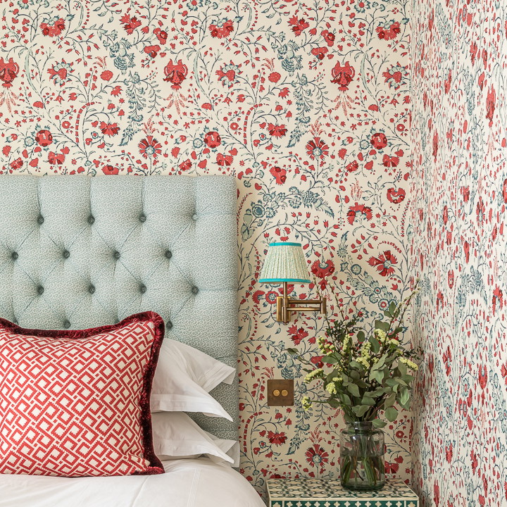 a bedroom with floral wallpaper and a bed