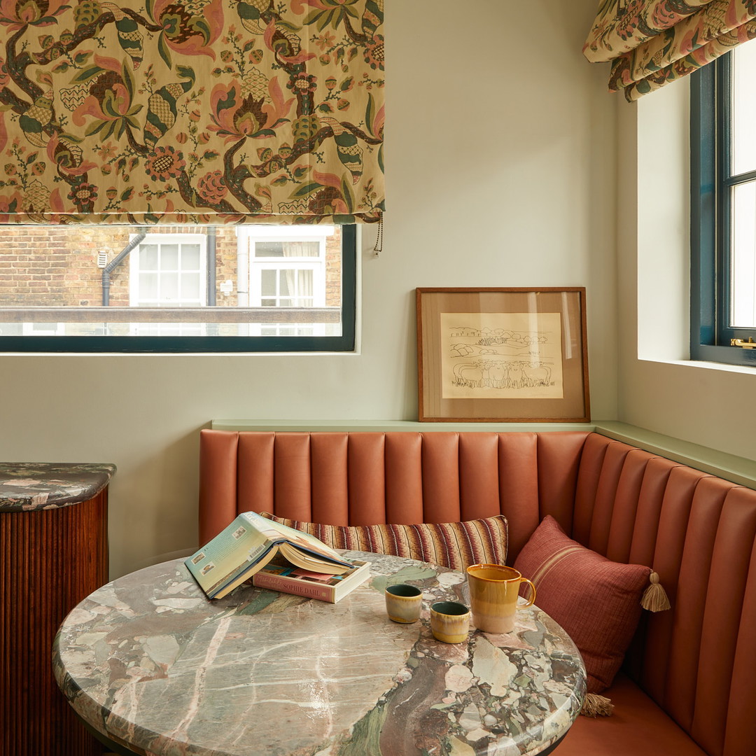 a corner table with a book and a vase on it