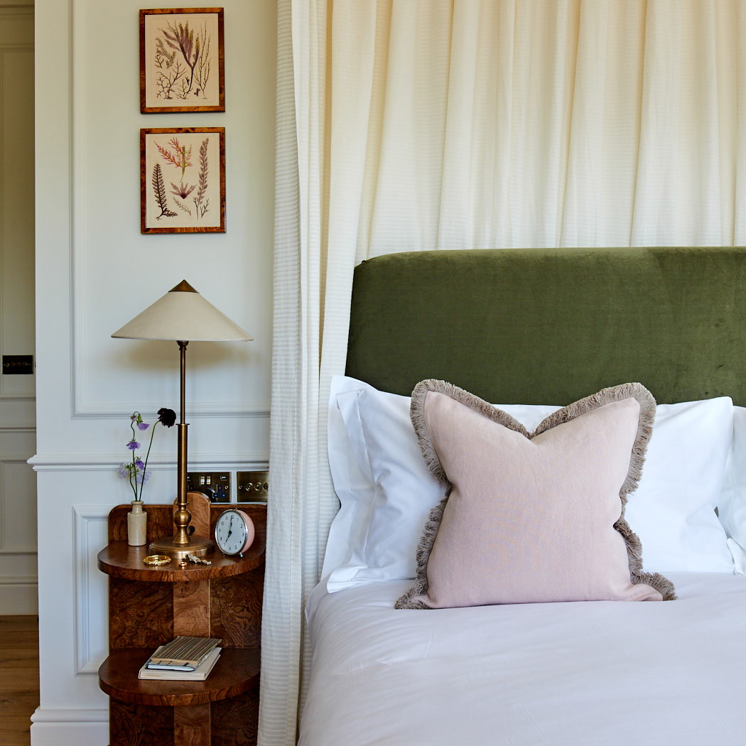 a bed with a green headboard and white sheets