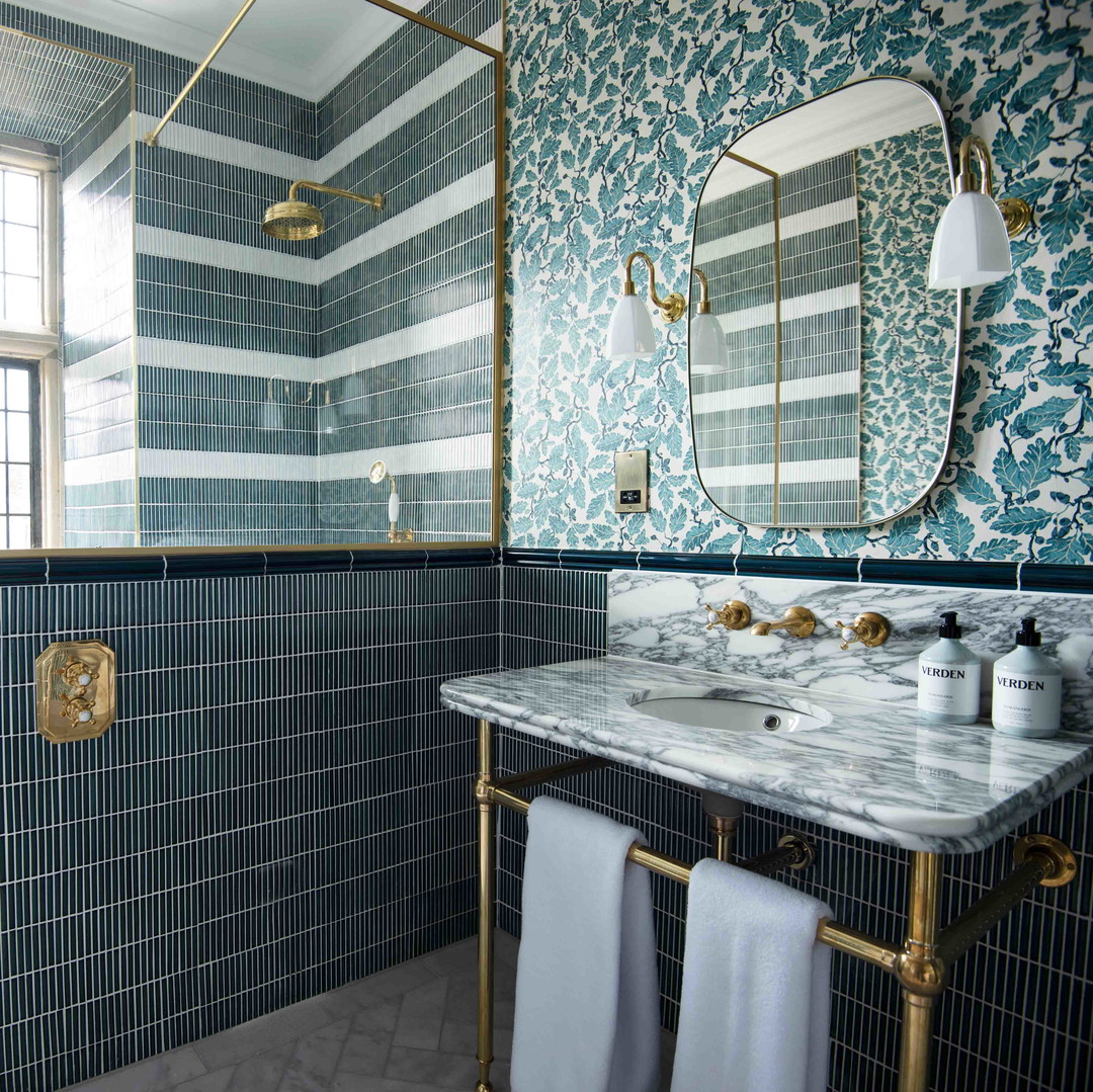 a bathroom with a sink, mirror, and tiled walls