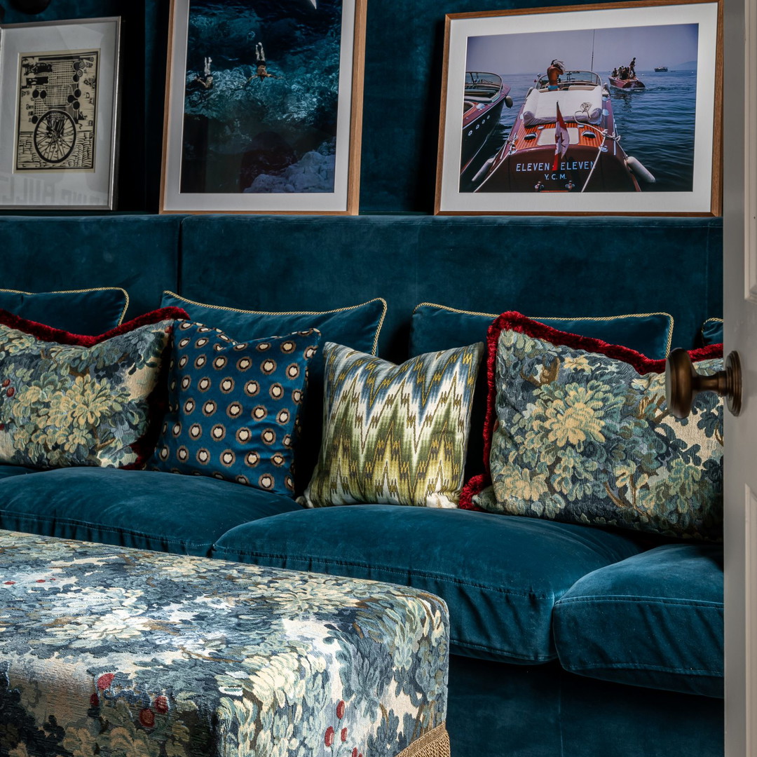 a living room with a blue couch and pictures on the wall