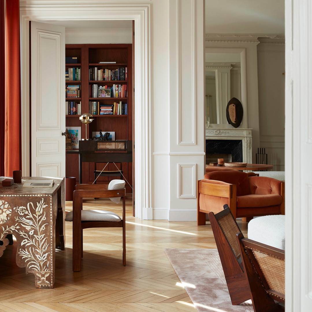 a room with a table, chairs, and bookshelf