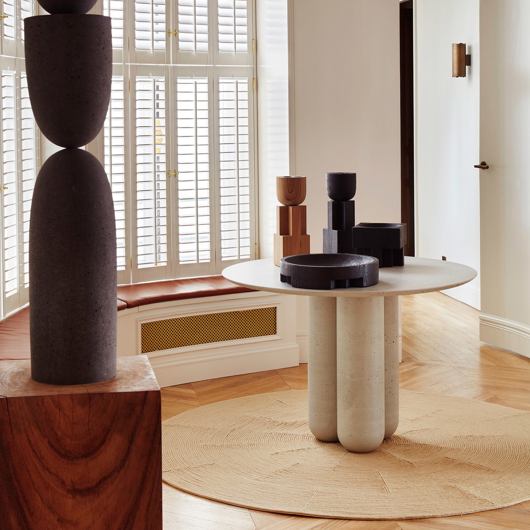 a living room with a round table and a large window