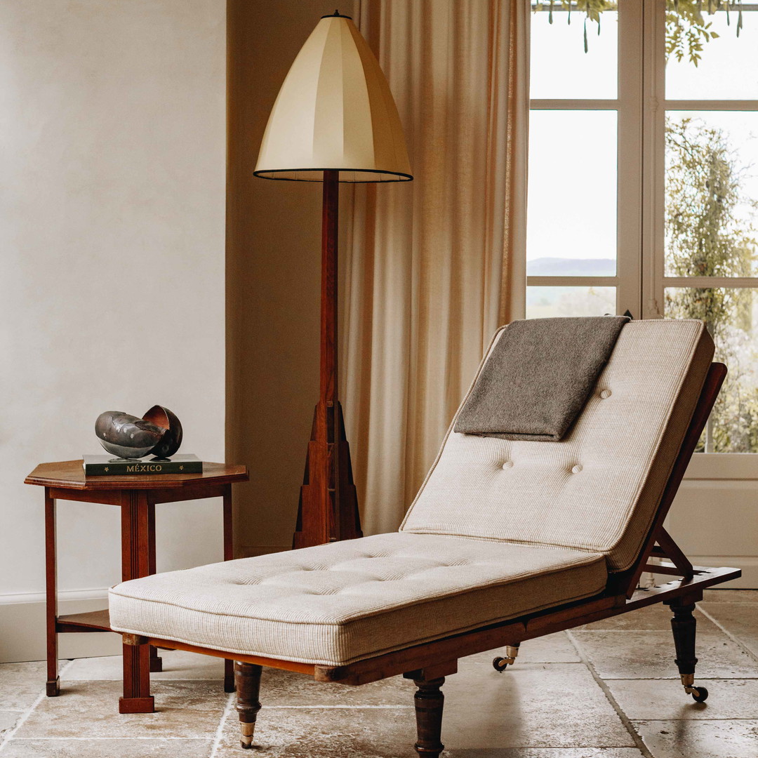 a chaise lounge chair sitting in front of a window