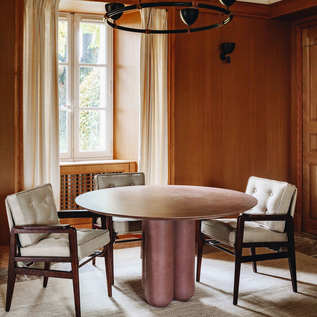 a dining room with a round table and chairs