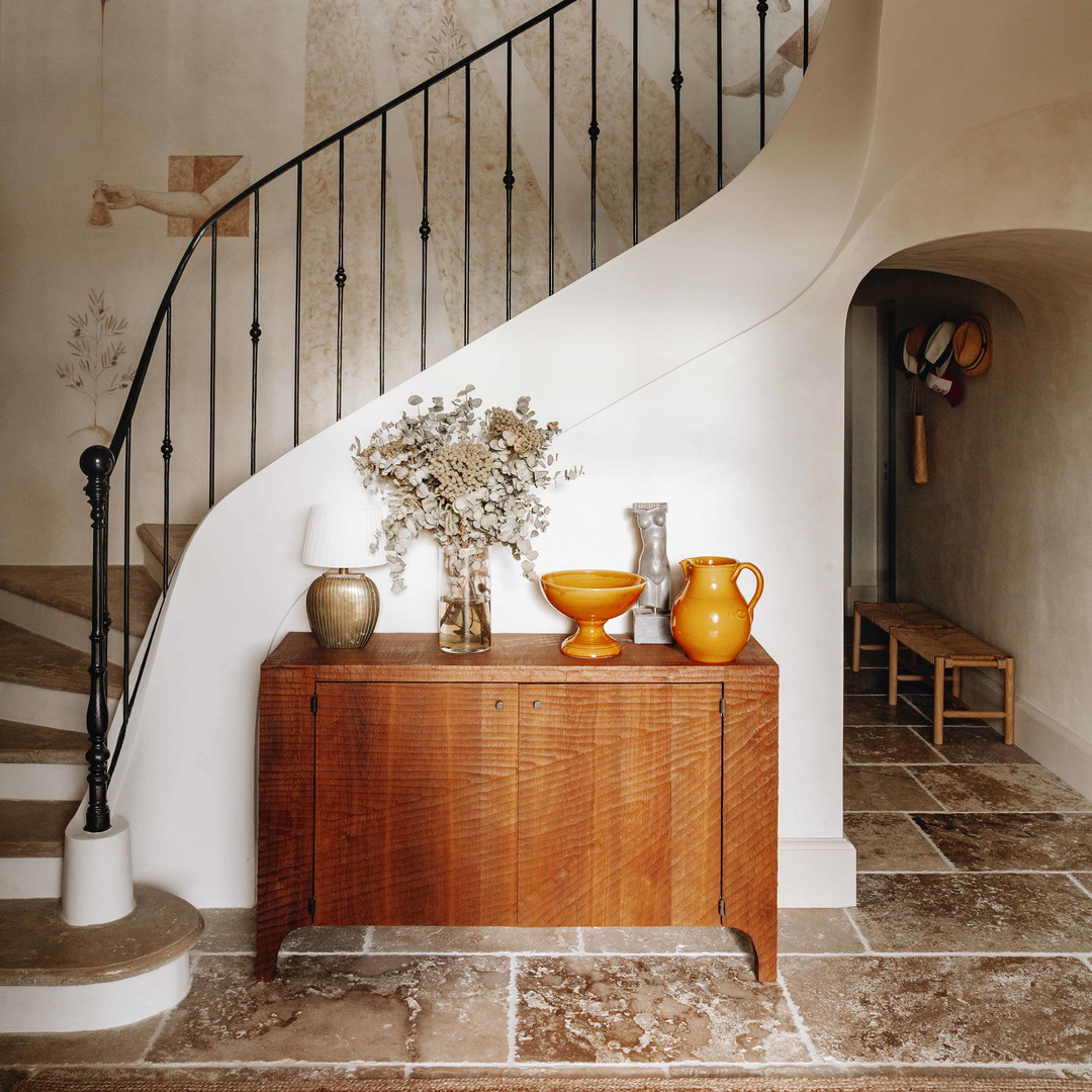 a room with a staircase and a painting on the wall