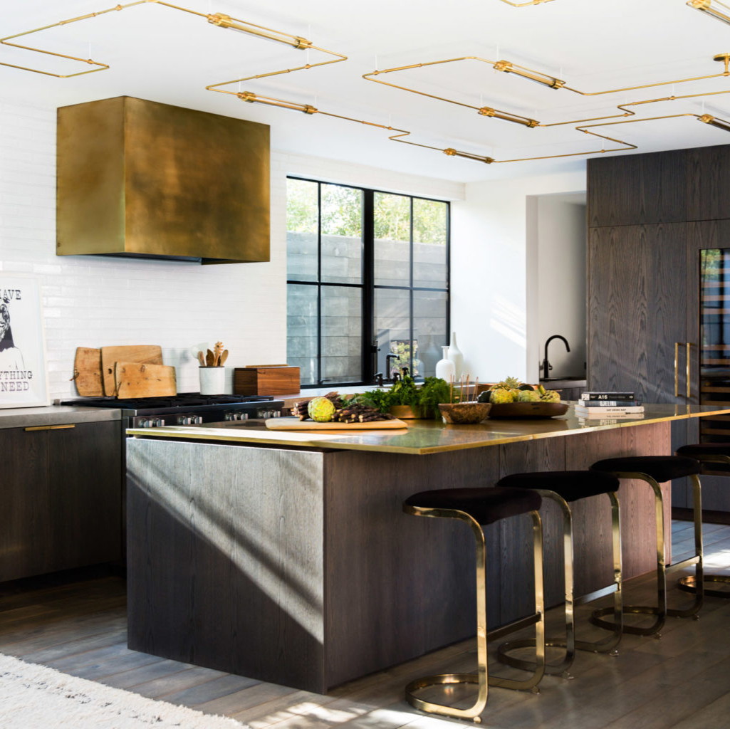 a modern kitchen with a large island and gold accents