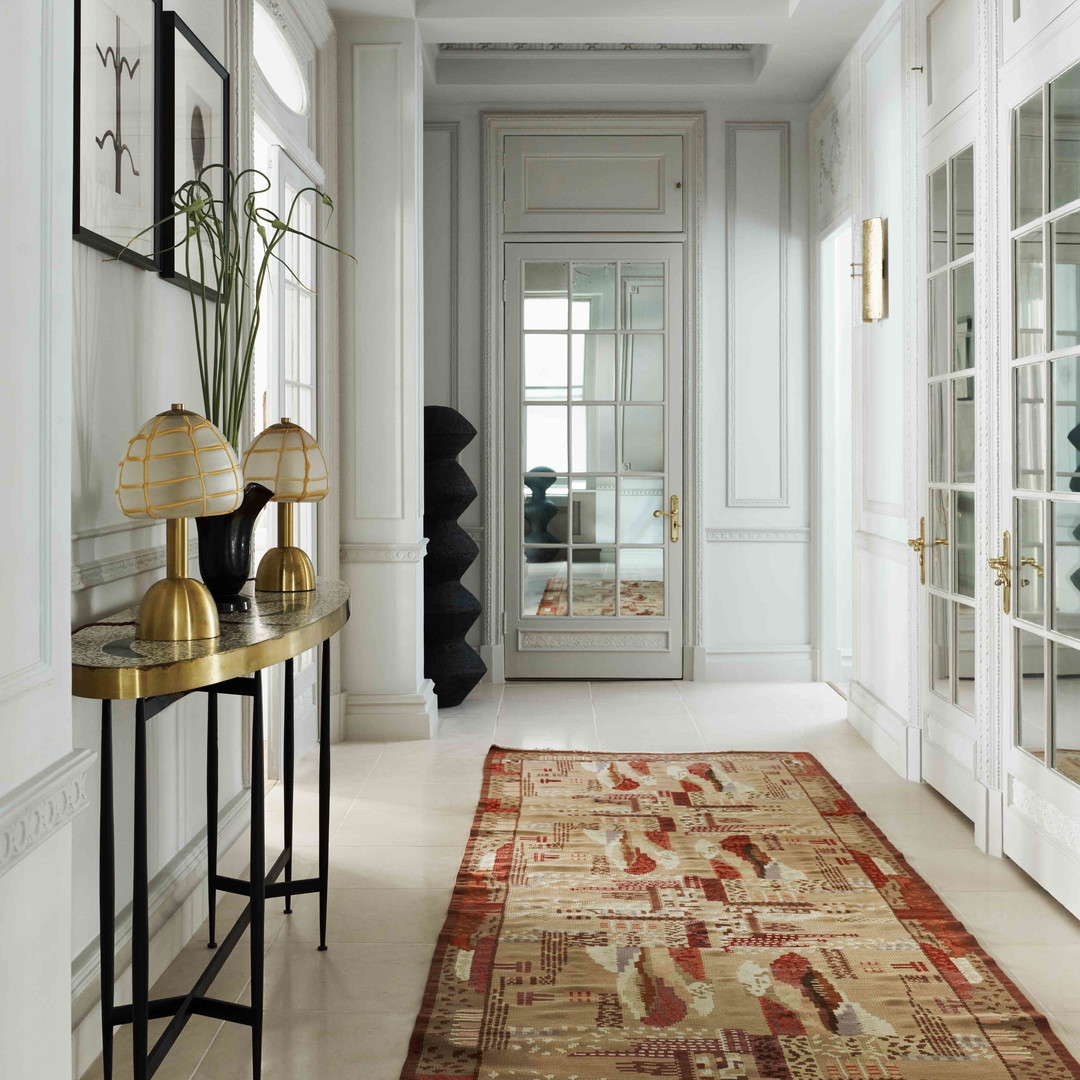 a hallway with a rug and two lamps