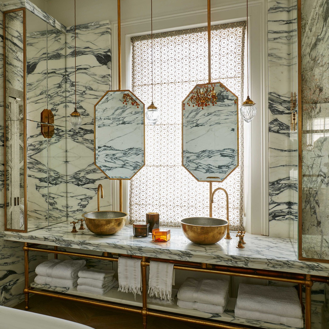 a bathroom with marble counter tops and gold fixtures