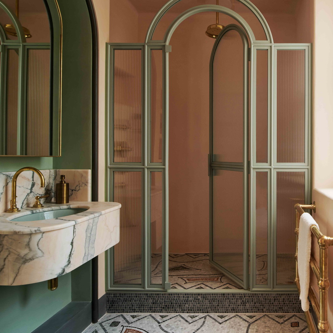 a bathroom with a glass shower door and a sink