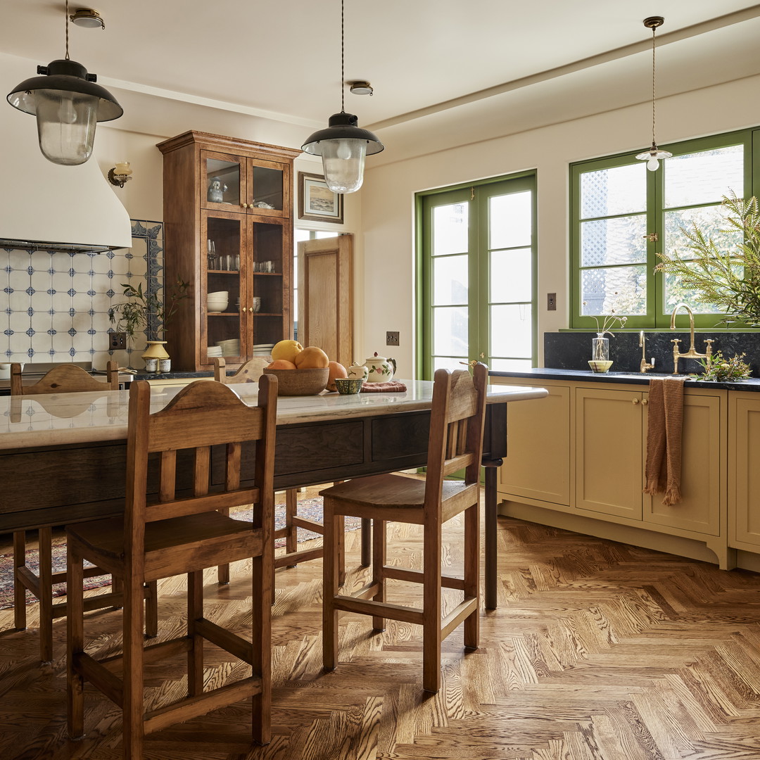 a kitchen with a table, chairs, cabinets and a window