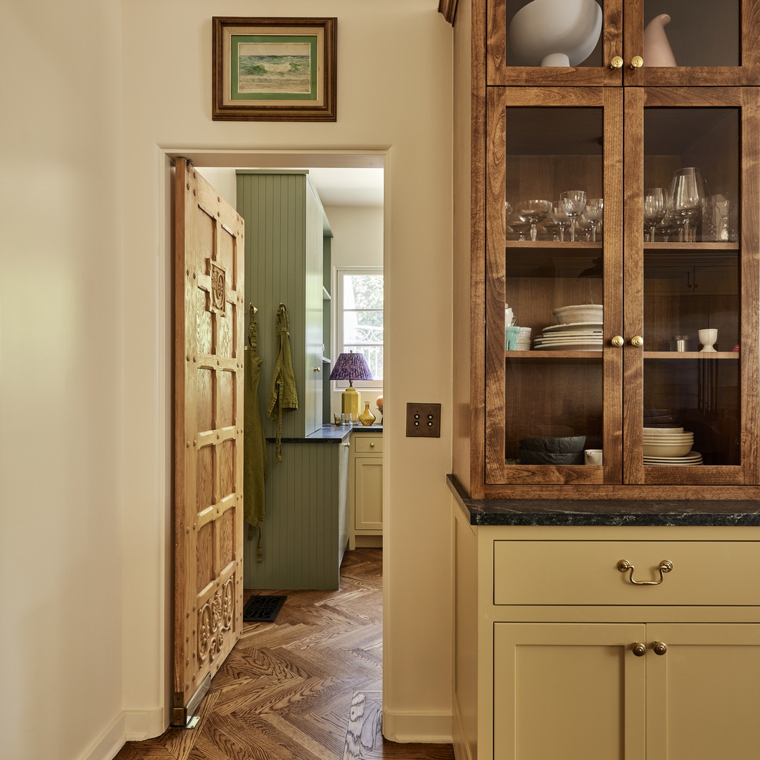 a kitchen with a large wooden cabinet in the middle of the room