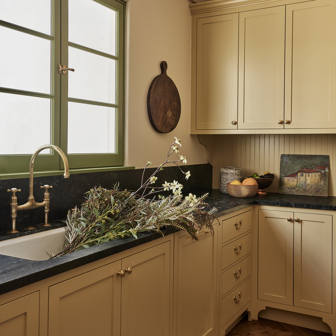 a kitchen with white cabinets and a black counter top