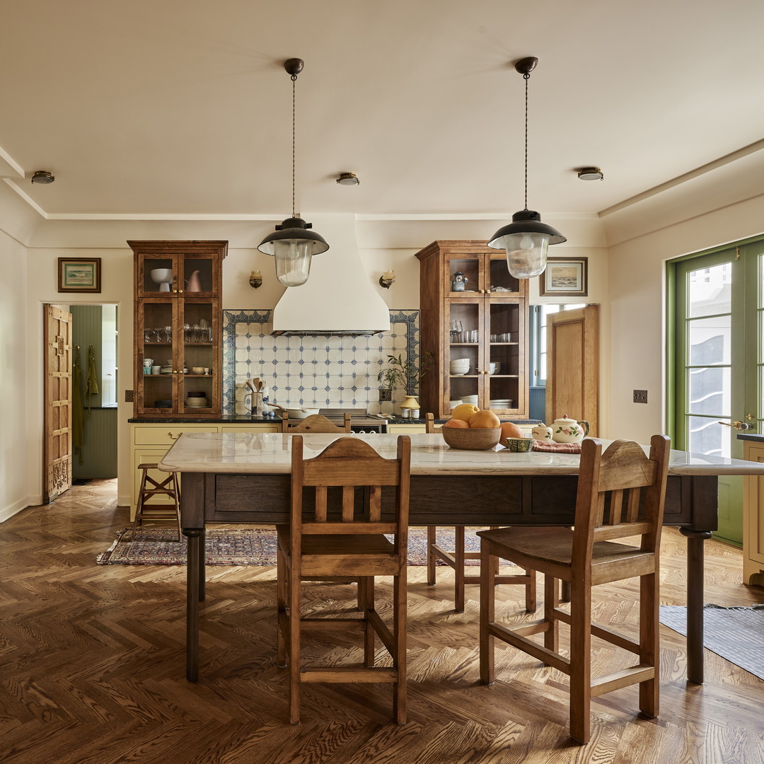 a kitchen with a table, chairs, cabinets and a window