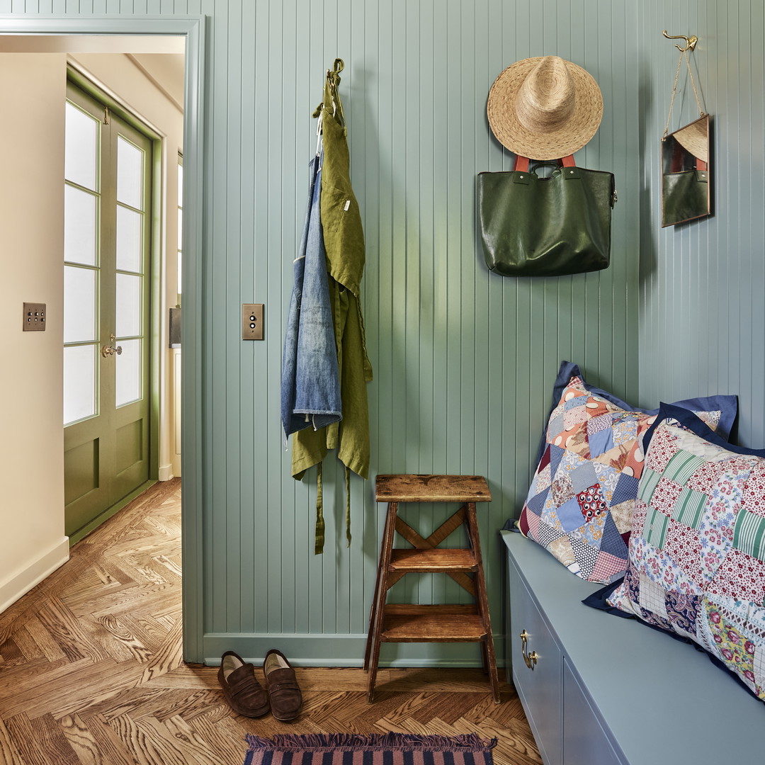 a room with a bench and a hat on the wall