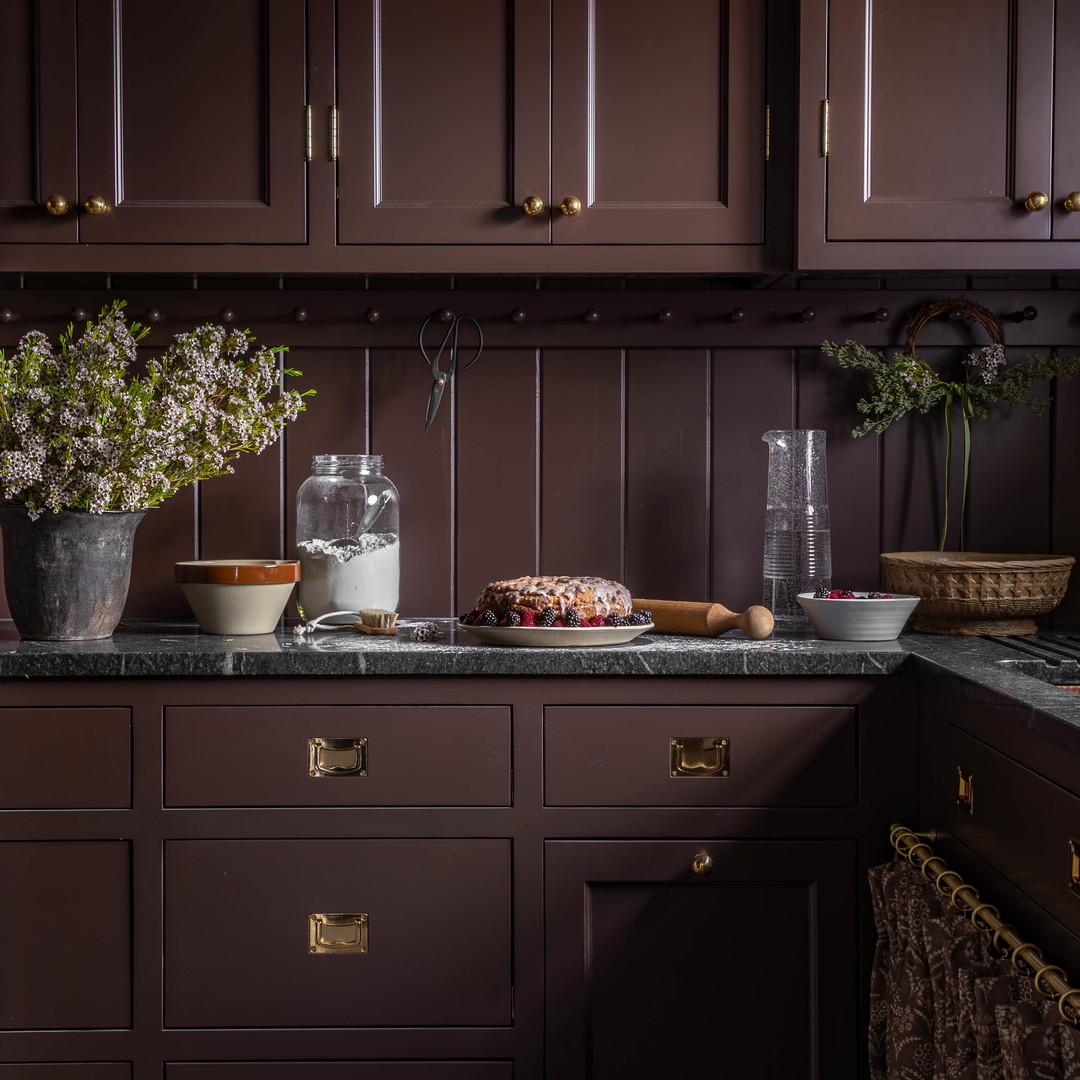 a kitchen with brown cabinets and marble counter tops