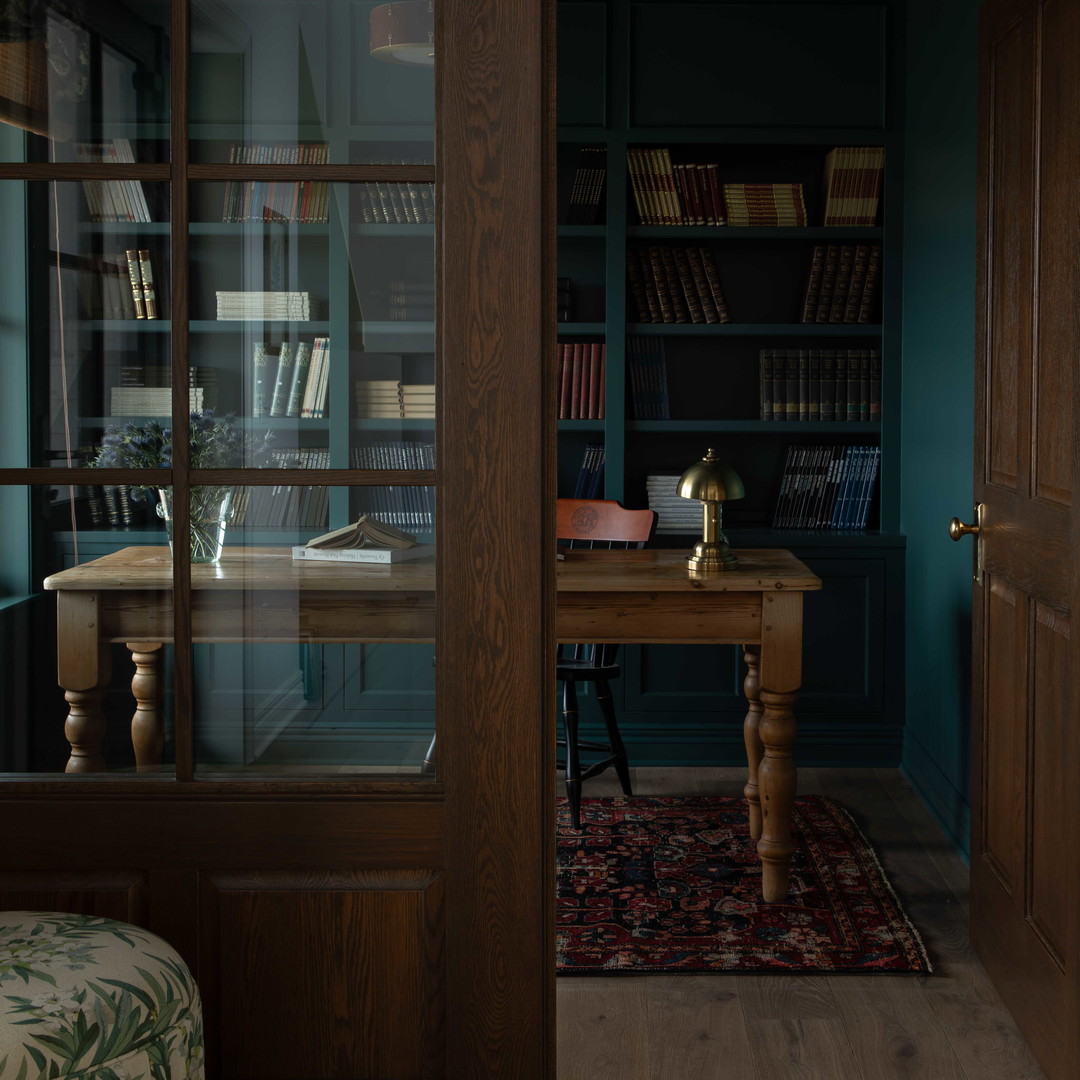 a room with a chair, desk and bookshelf