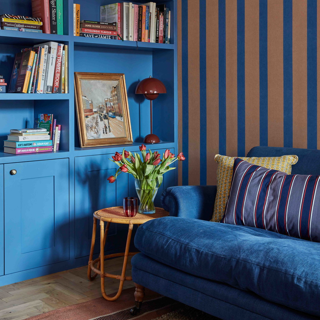 a living room with a blue couch and bookshelf