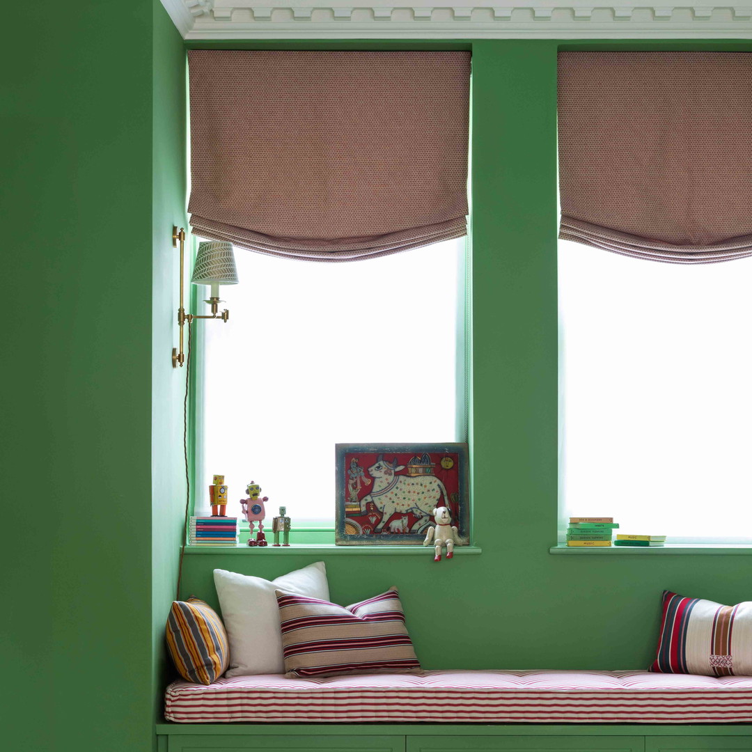 a child's bedroom with green walls and a window seat