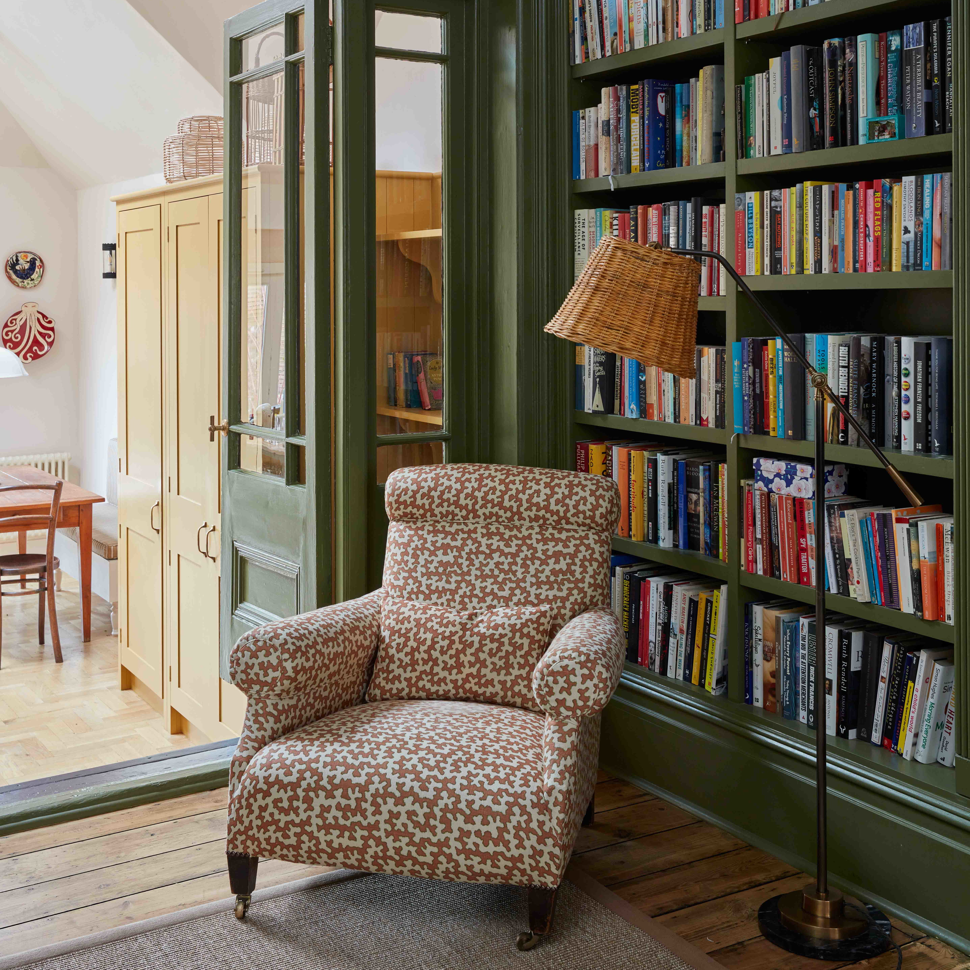 a living room with a chair and a book shelf