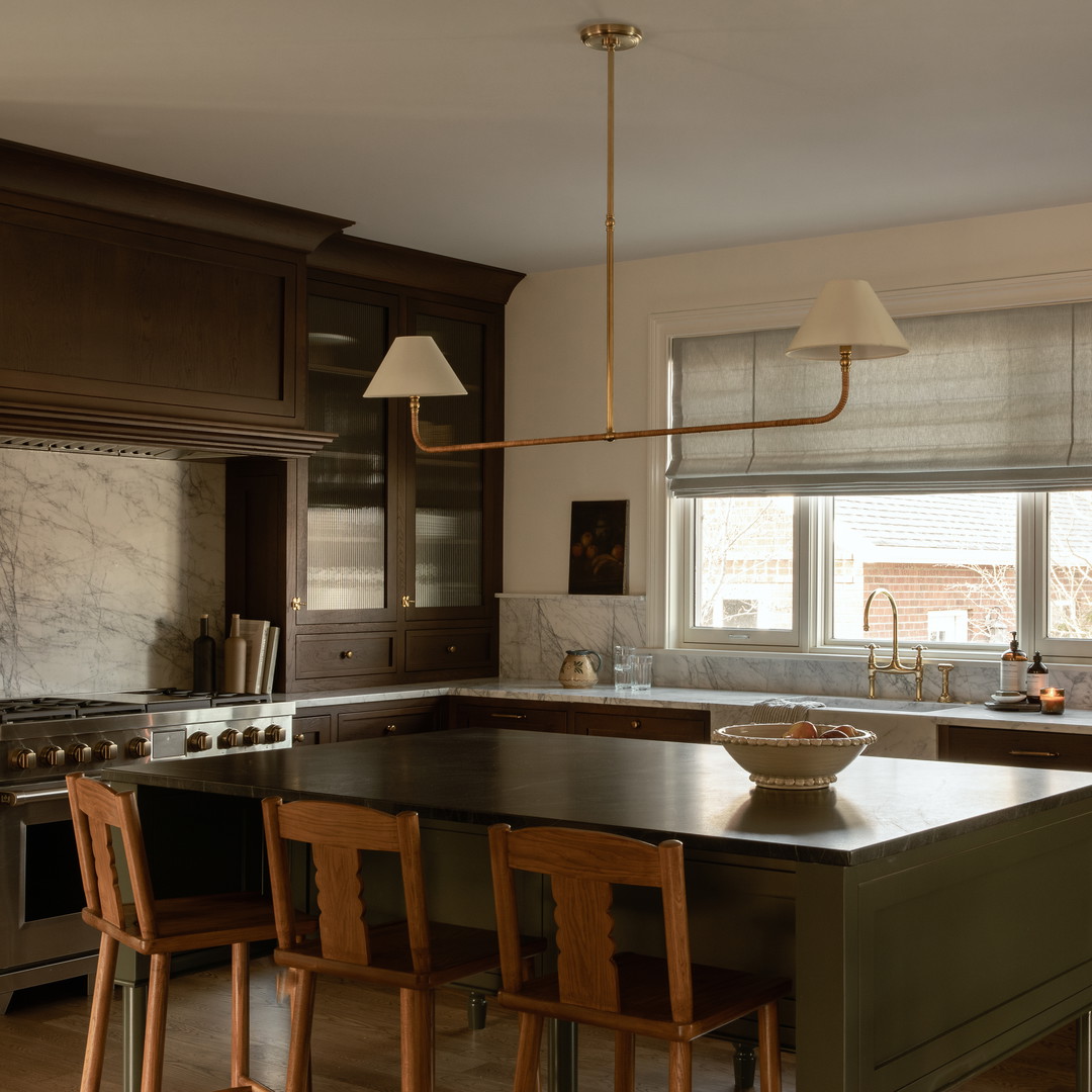 a kitchen with a center island and wooden chairs